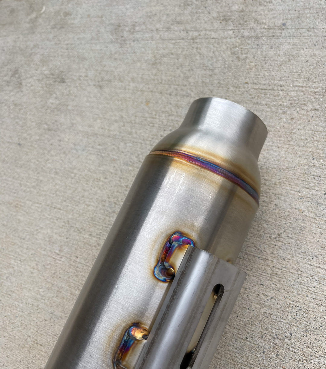 Close-up of Stealth Pipes Pipe Bomb Muffler – stainless TIG welds and engraved logo