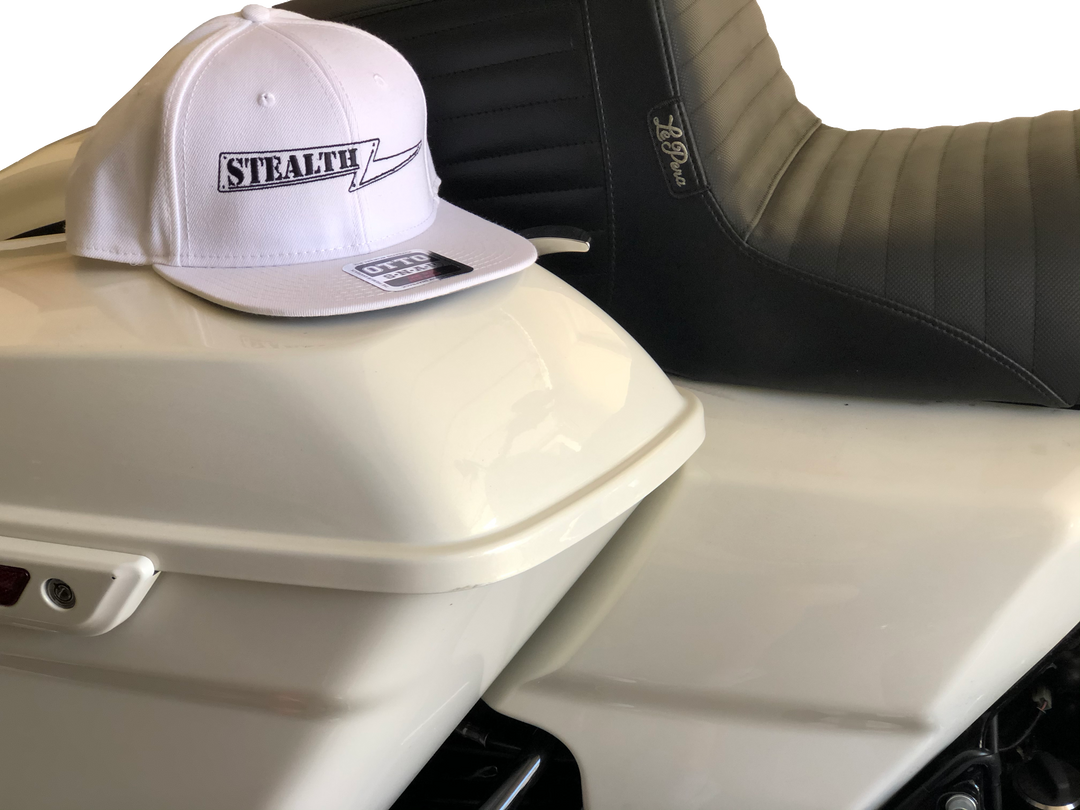 White Stealth Pipes snapback hat displayed on a motorcycle seat