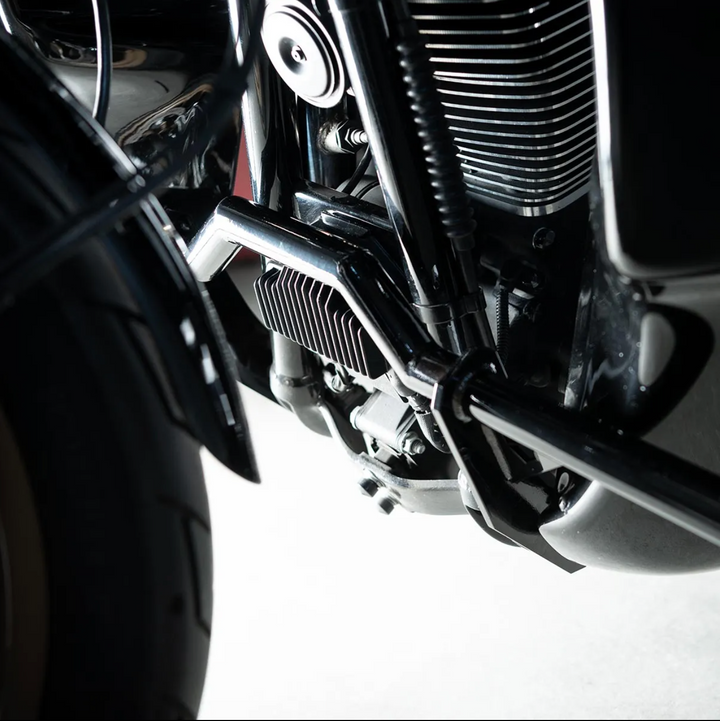 A black motorcycle crash bar installed on a motorcycle, designed to protect the paint job during falls or tipovers.