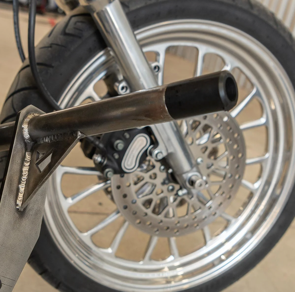 A black metal Dyna Crash Bar designed for motorcycle stunt riding, includes two Delrin sliders, displayed on a white background.