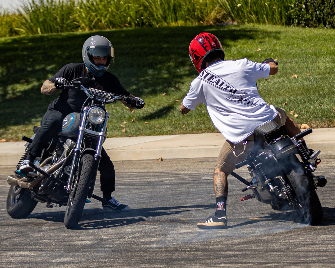 Motorcycle rider in Stealth Rider T-shirt captured from behind while riding